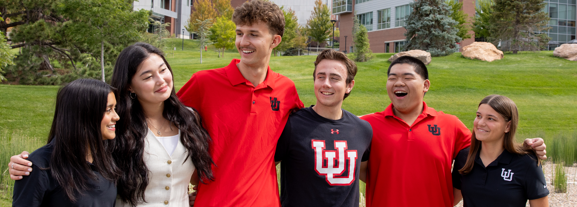 Students outdoors with arms around eachother.