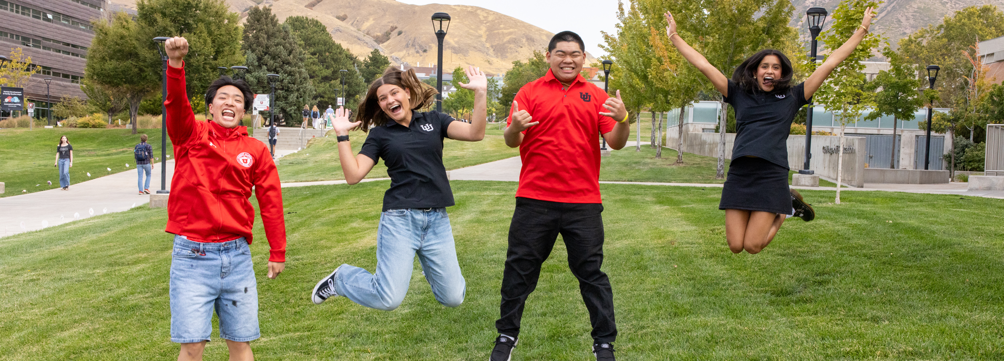 Eccles Students jumping with mountains in the background.